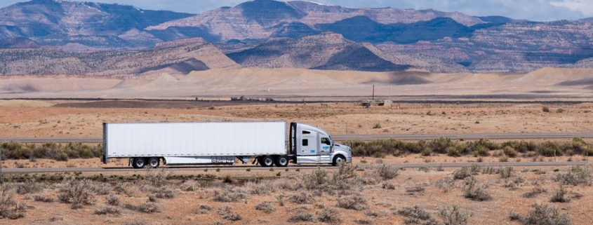panoramic view of a dry van trailer driving through the desert